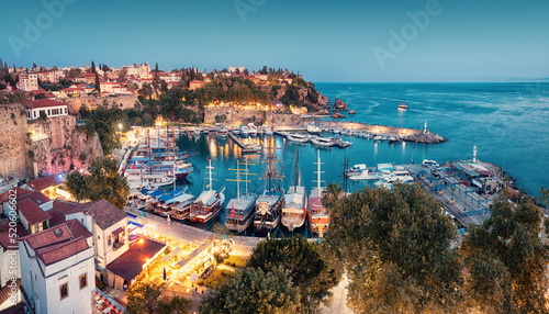 Fototapeta Naklejka Na Ścianę i Meble -  Aerial night view of the picturesque harbor with marina port with cruise tourist ships near the old town of Kaleici in Antalya. Turkish Riviera and travel in resort paradise