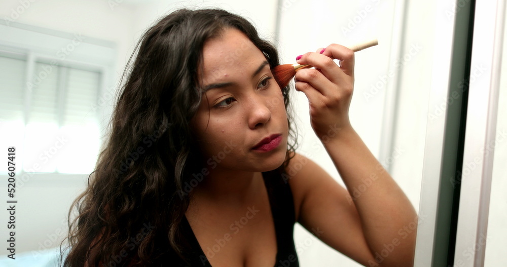 Latina hispanic girl applying make-up. Young woman preparing to go out in front of mirror reflection Latina hispanic girl applying make-up. Young woman preparing to go out in front of mirror reflection