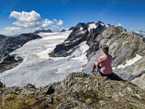 young woman enjoying the view over the mountains and the glacier. Magical moment to enjoy. Swiss Alps.High quality photo