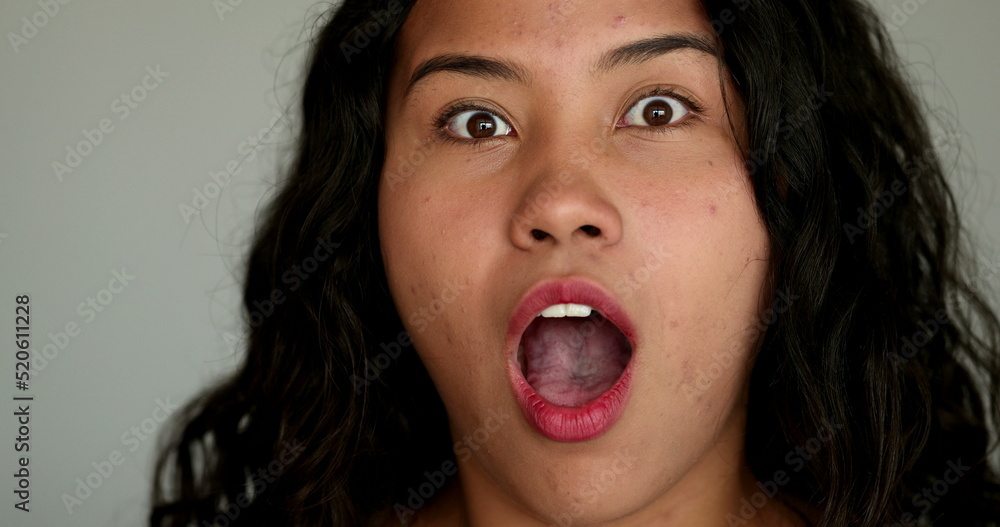 Hispanic girl shock surprise reaction covering mouth with hands Hispanic girl shock surprise reaction covering mouth with hands