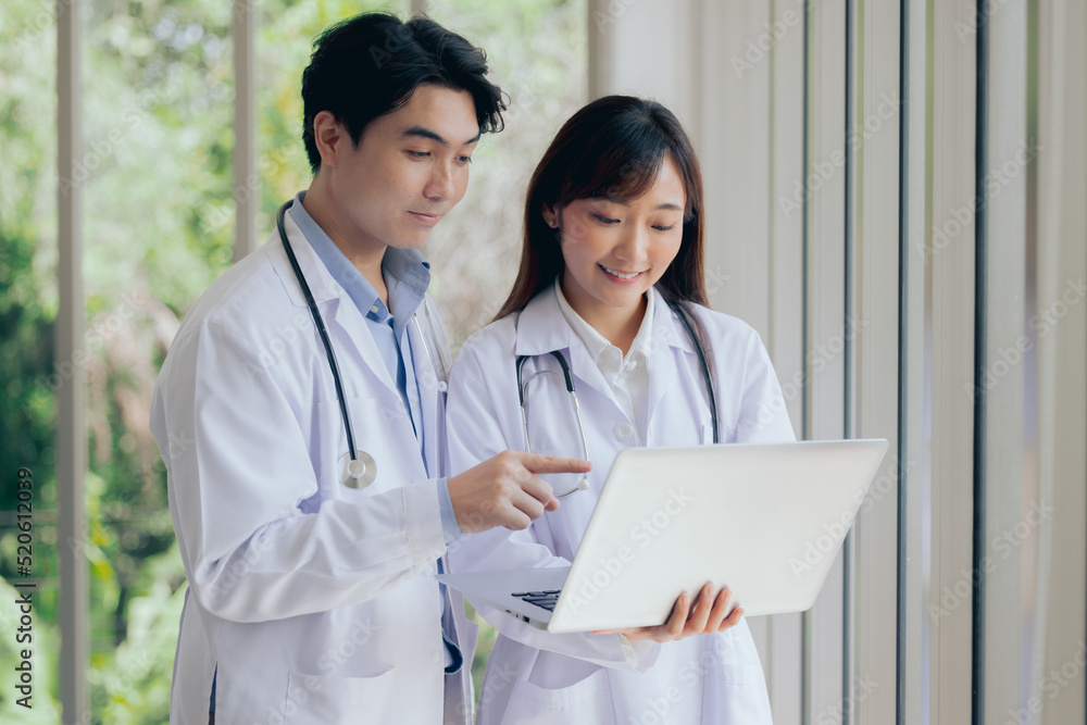 Asian two male female professional doctor using computer laptop checking patient's medical records ,Portrait doctor healthcare professionals Asian two male female professional doctor using computer laptop checking patient's medical records ,Portrait doctor healthcare professionals
