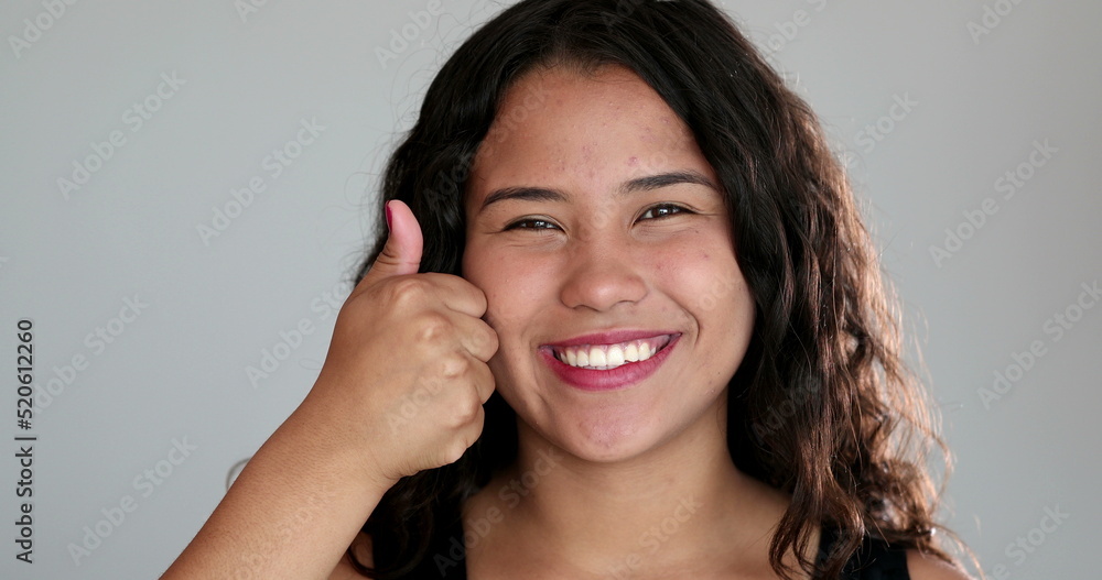 Hispanic girl giving approval gesture with hand, latina giving thumbs up with hand Hispanic girl giving approval gesture with hand, latina giving thumbs up with hand