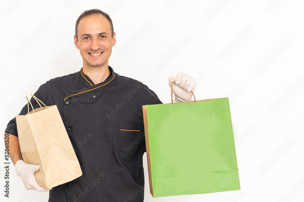 Delivery man employee in t-shirt uniform, glove hold craft paper packet with food isolated on white background. Delivery man employee in t-shirt uniform, glove hold craft paper packet with food isolated on white background.