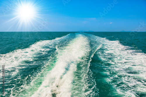 Wave on sea from speed boat on blue sea with sun rays on sky © Pavlo Vakhrushev