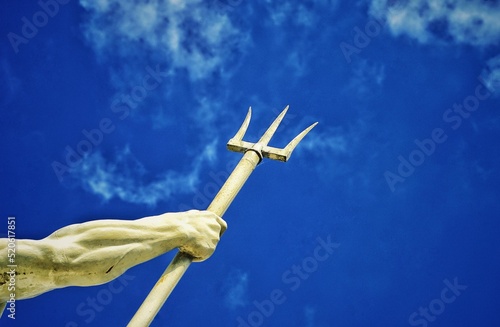 Obraz na plátně Hand of the mighty god of the sea and oceans Neptune (Poseidon) holding his trident