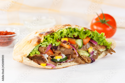 Döner Kebab Doner Kebap fast food in flatbread on a wooden board