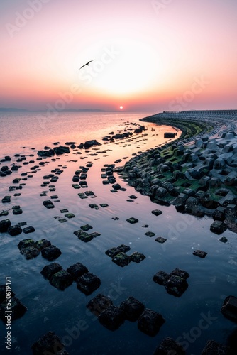 Vertical shot of Batu Bintang beach with stony squares in Indonesia during sunset photo