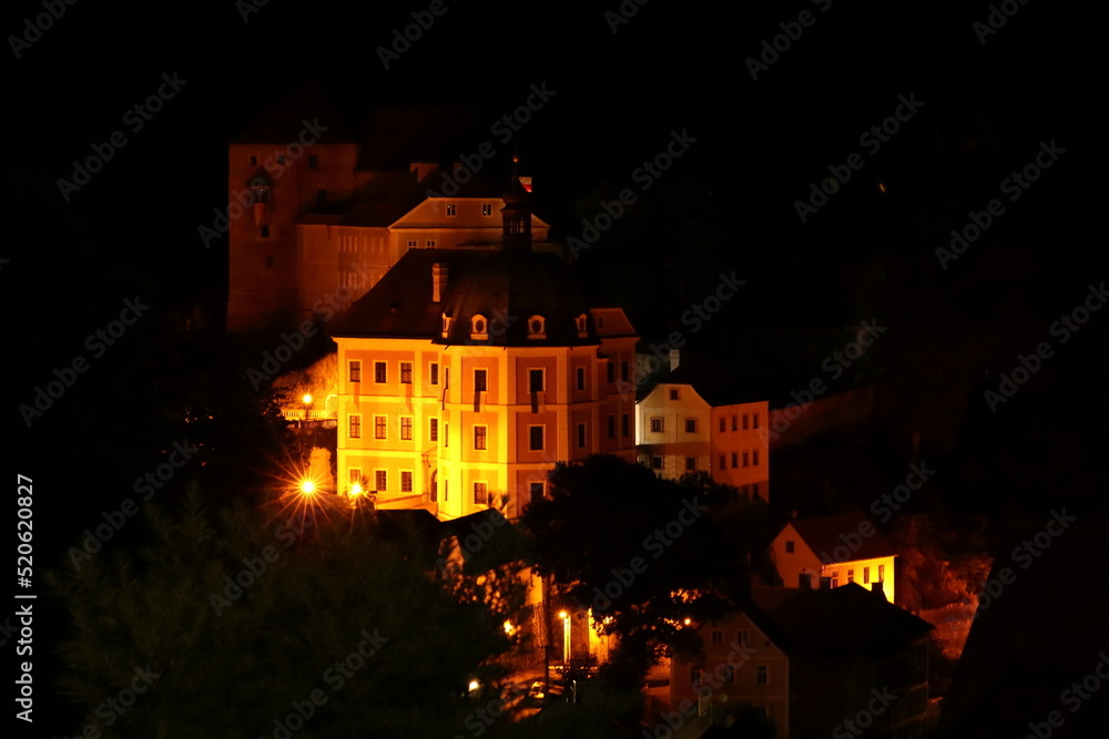 Bečov State Castle illuminated by lights at night in the dark