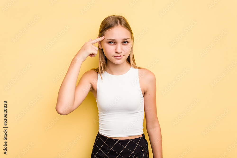 Young caucasian girl isolated on yellow background pointing temple with finger, thinking, focused on a task. Young caucasian girl isolated on yellow background pointing temple with finger, thinking, focused on a task.
