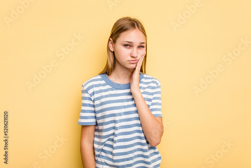 Young caucasian girl isolated on yellow background having a strong teeth pain, molar ache.