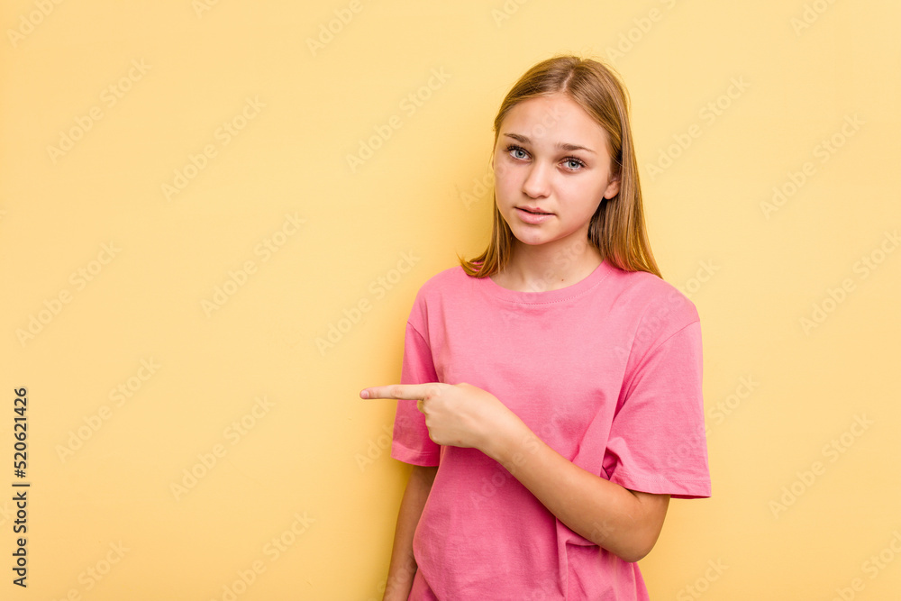 Young caucasian girl isolated on yellow background pointing to the side Young caucasian girl isolated on yellow background pointing to the side