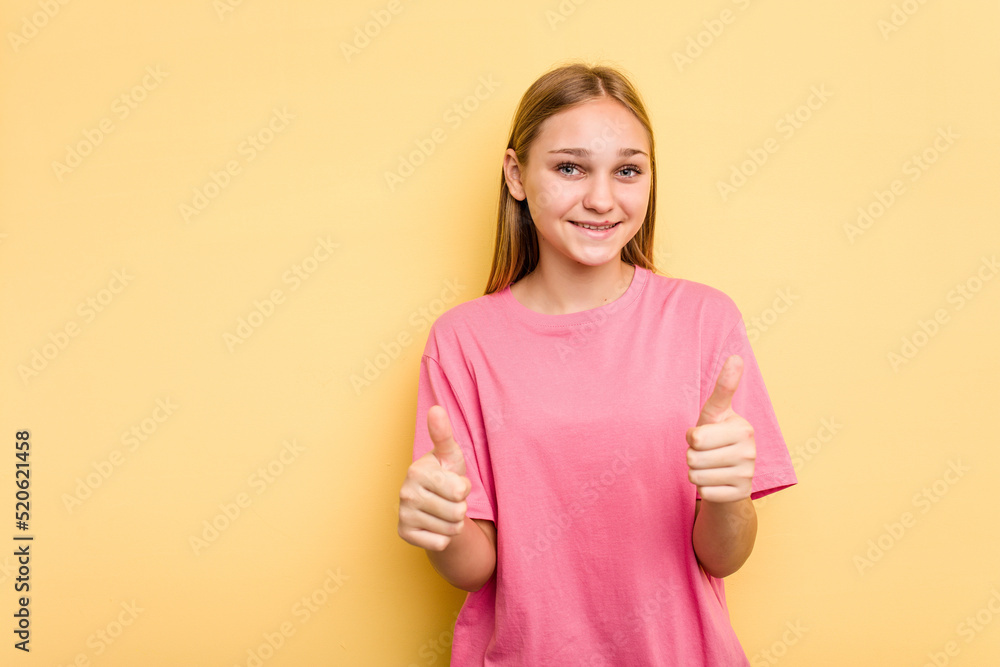 Young caucasian girl isolated on yellow background smiling and raising thumb up Young caucasian girl isolated on yellow background smiling and raising thumb up