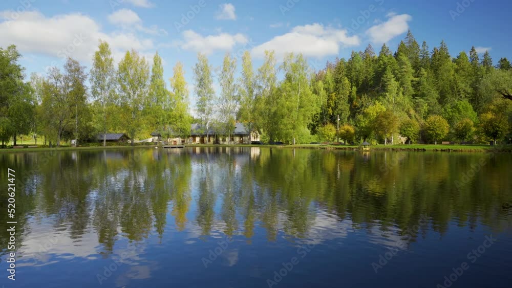 Lake in the Gauja National Park in autumn. One-storey old house on the coast. A high hill of red sand against a blue sky. Ligatne, Latvia Lake in the Gauja National Park in autumn. One-storey old house on the coast. A high hill of red sand against a blue sky. Ligatne, Latvia