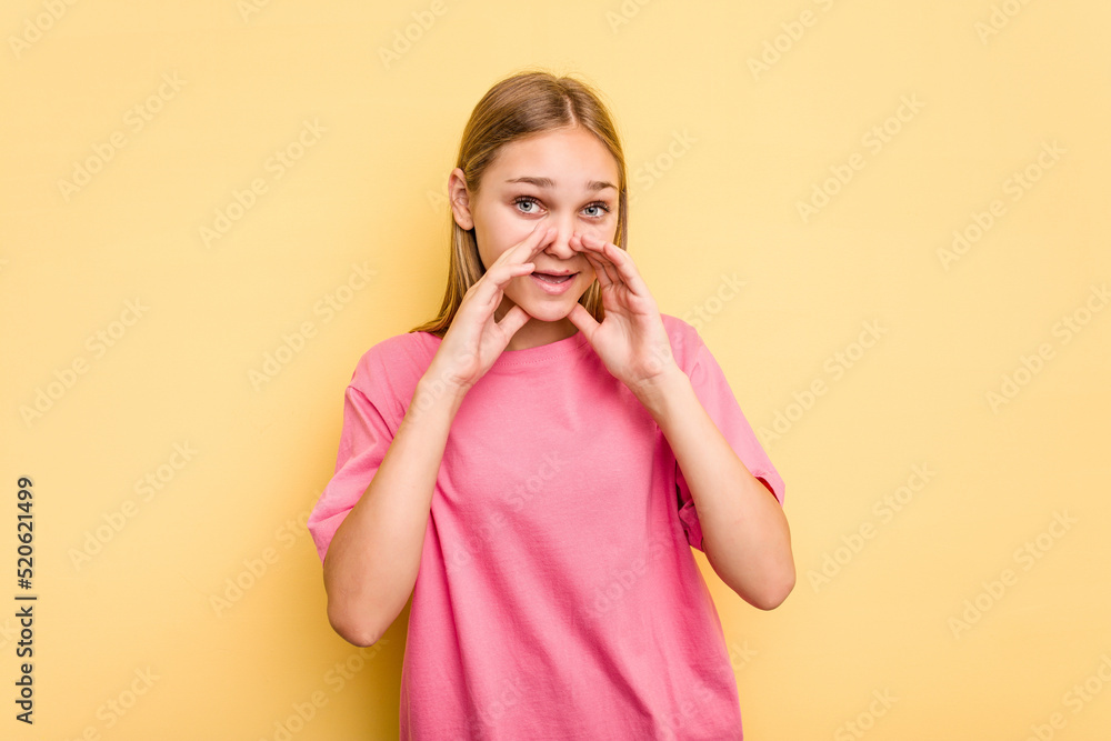 Young caucasian girl isolated on yellow background saying a gossip, pointing to side reporting something. Young caucasian girl isolated on yellow background saying a gossip, pointing to side reporting something.