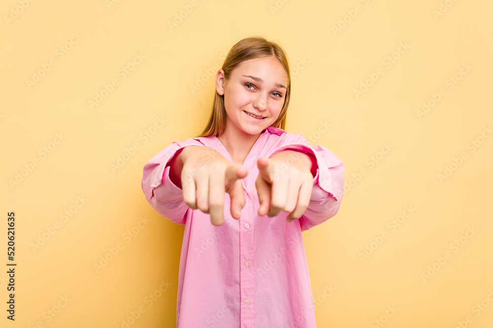 Young caucasian girl isolated on yellow background pointing to front with fingers. Young caucasian girl isolated on yellow background pointing to front with fingers.