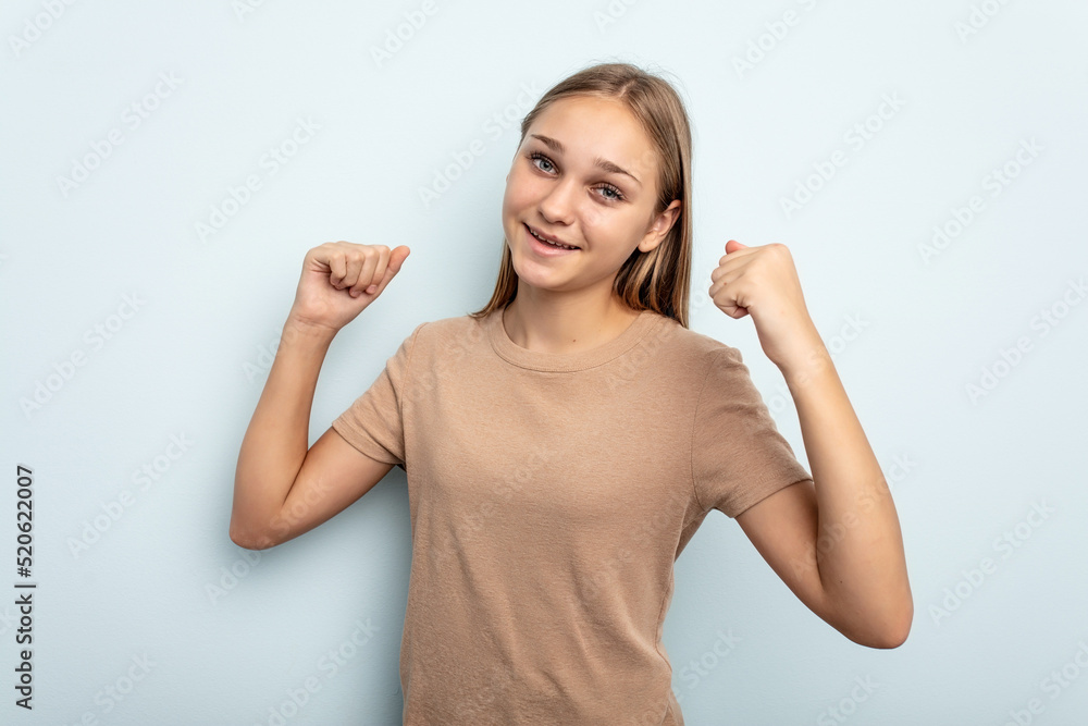 Young caucasian girl isolated on blue background cheering carefree and excited. Victory concept. Young caucasian girl isolated on blue background cheering carefree and excited. Victory concept.