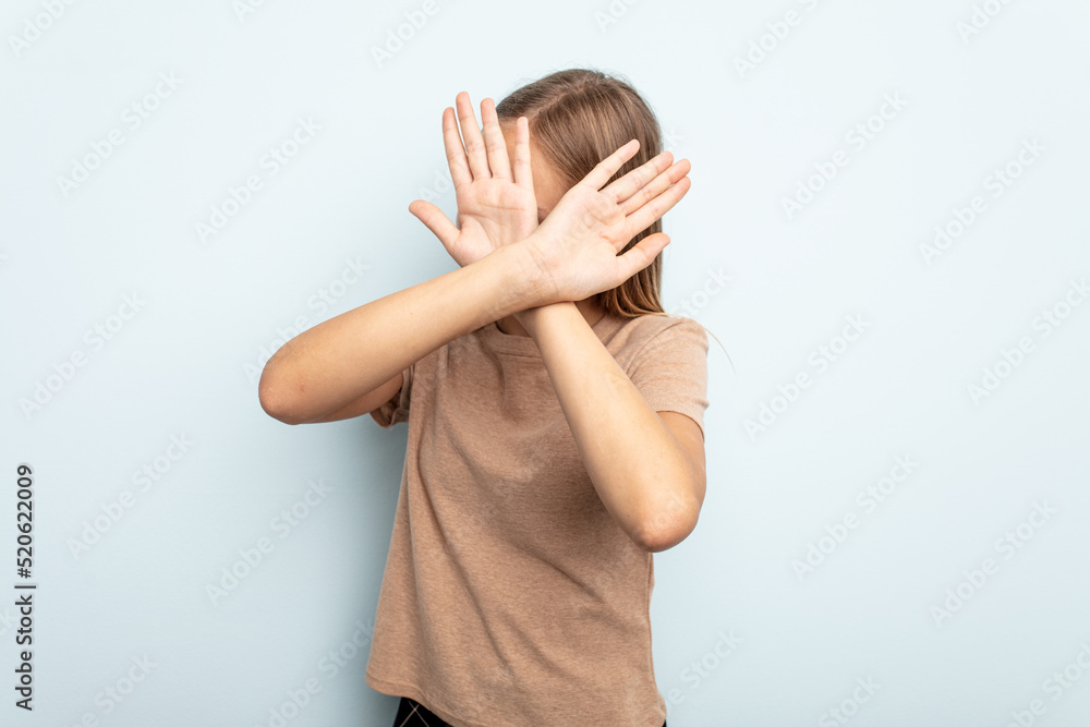 Young caucasian girl isolated on blue background keeping two arms crossed, denial concept. Young caucasian girl isolated on blue background keeping two arms crossed, denial concept.