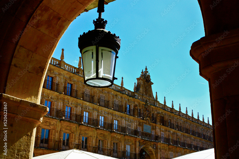 Traditional lantern in an arch of the main square of Salamanca, Spain, in a sunny summer day with a bright blue sky