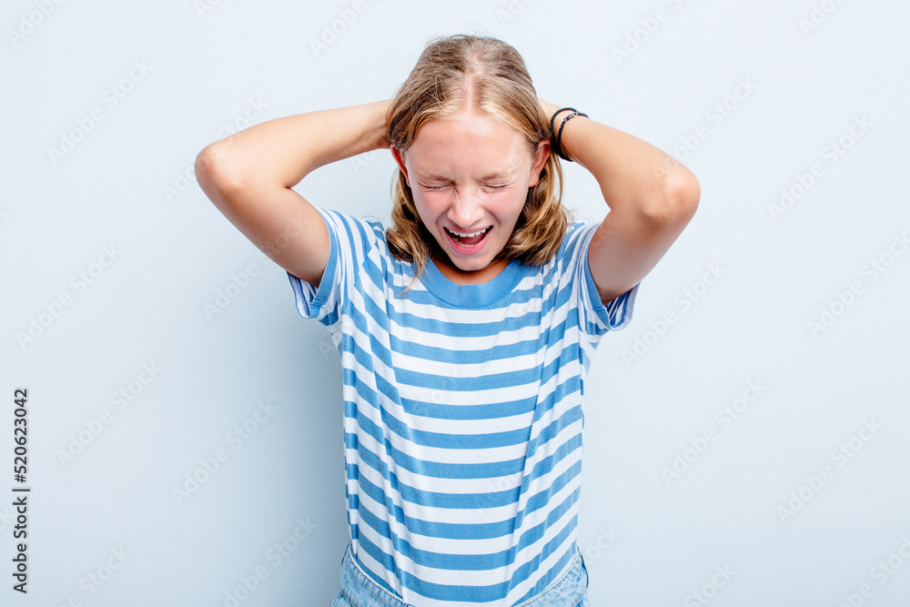 Caucasian teen girl isolated on blue background covering ears with hands trying not to hear too loud sound. Caucasian teen girl isolated on blue background covering ears with hands trying not to hear too loud sound.