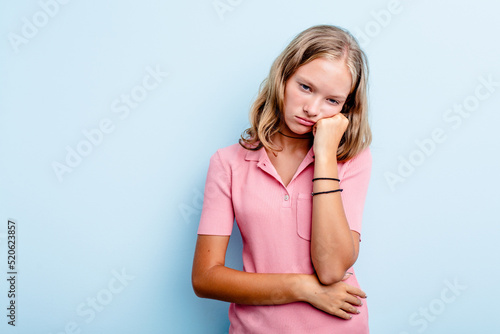 Caucasian teen girl isolated on blue background who feels sad and pensive  looking at copy space.