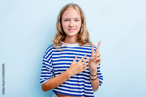 Caucasian teen girl isolated on blue background taking an oath, putting hand on chest.