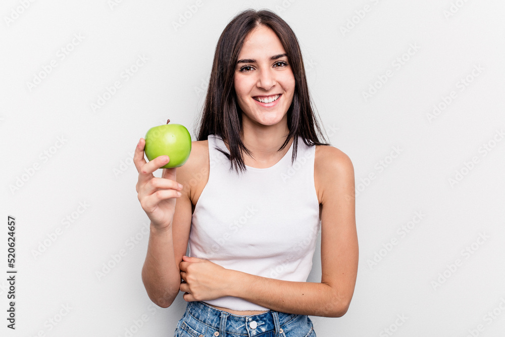 Young caucasian woman holding an apple isolated on white background laughing and having fun. Young caucasian woman holding an apple isolated on white background laughing and having fun.