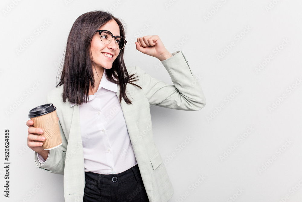 Young business caucasian woman holding takeaway coffee isolated on white background raising fist after a victory, winner concept. Young business caucasian woman holding takeaway coffee isolated on white background raising fist after a victory, winner concept.