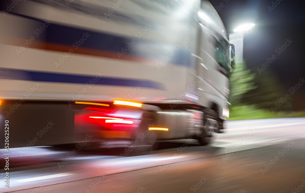 Truck rushes at night along the illuminated road. Truck rushes at night along the illuminated road.