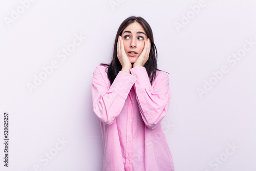 Young caucasian woman isolated on pink background scared and afraid.