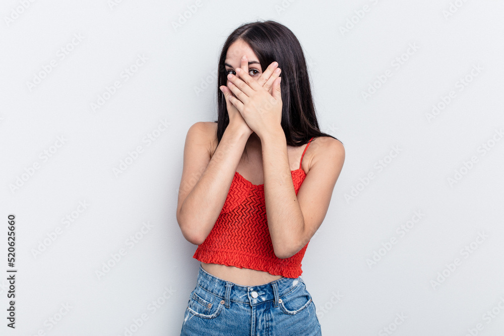 Young caucasian woman isolated on white background blink through fingers frightened and nervous. Young caucasian woman isolated on white background blink through fingers frightened and nervous.