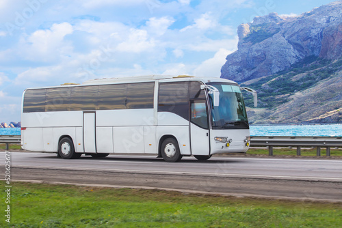 Tourist bus moves along the mountains on the sea