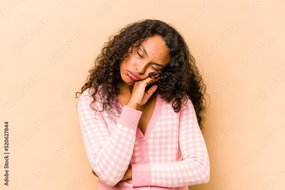Young hispanic woman isolated on beige background tired of a repetitive task. Young hispanic woman isolated on beige background tired of a repetitive task.