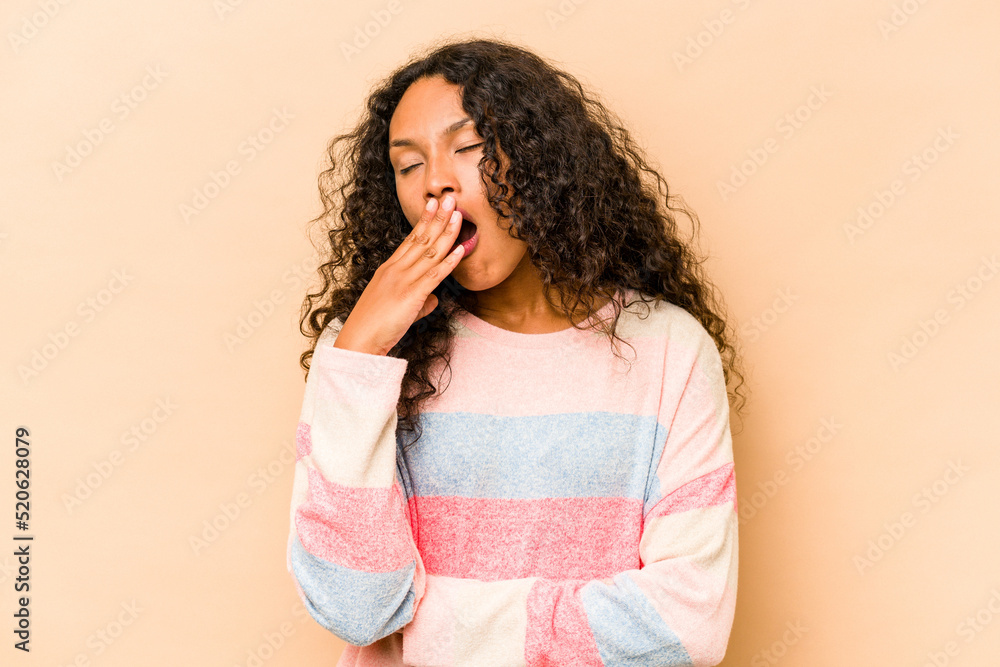 Young hispanic woman isolated on beige background yawning showing a tired gesture covering mouth with hand. Young hispanic woman isolated on beige background yawning showing a tired gesture covering mouth with hand.