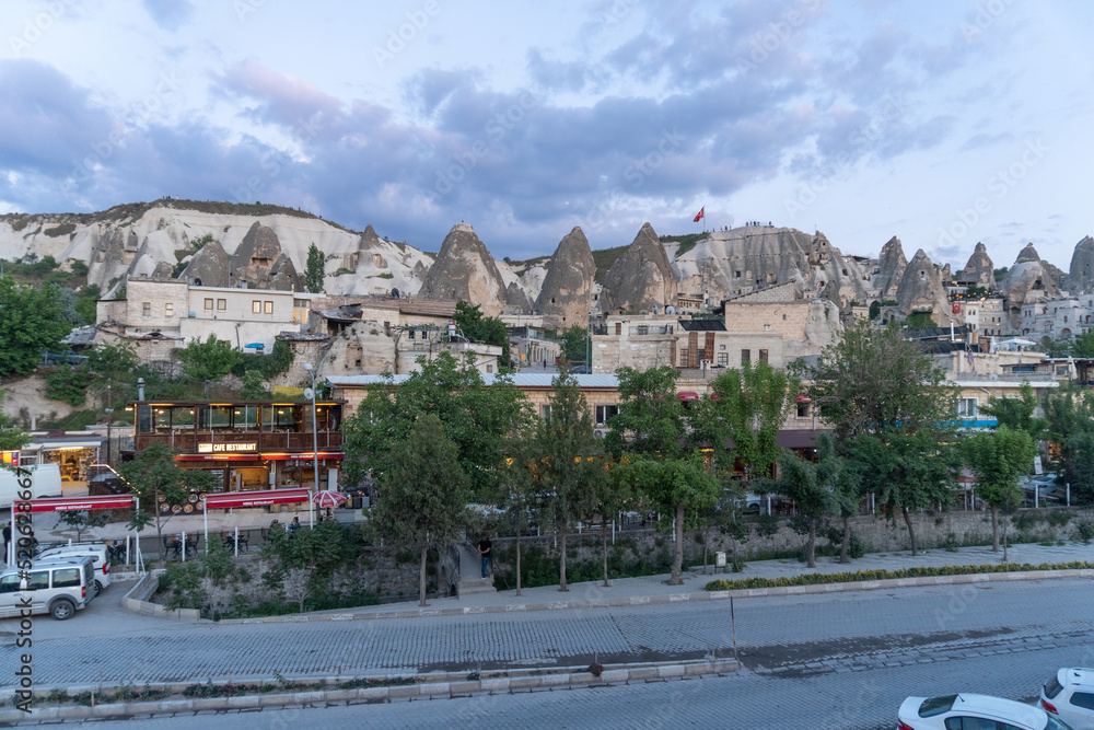 Hill of the city of Goreme in Cappadocia, with the flag of Turkey on top, at sunset