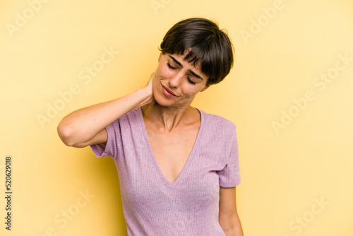 Young caucasian woman with a short hair cut isolated having a neck pain due to stress, massaging and touching it with hand.