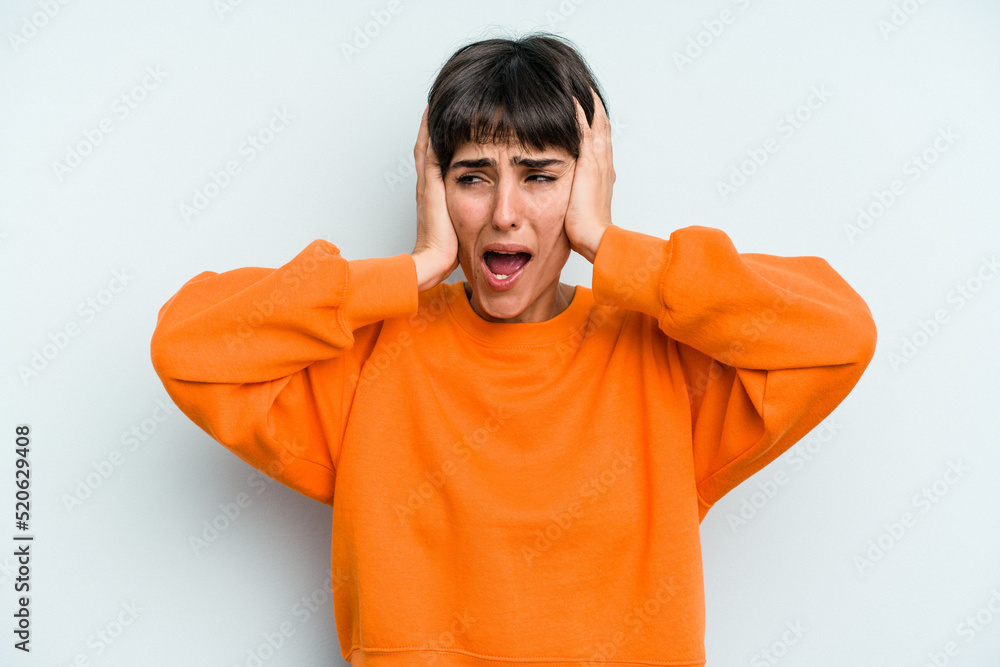 Young caucasian woman with a short hair cut isolated covering ears with hands trying not to hear too loud sound. Young caucasian woman with a short hair cut isolated covering ears with hands trying not to hear too loud sound.