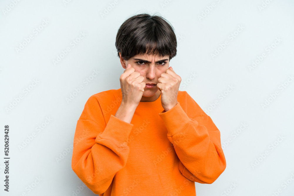 Young caucasian woman with a short hair cut isolated throwing a punch, anger, fighting due to an argument, boxing. Young caucasian woman with a short hair cut isolated throwing a punch, anger, fighting due to an argument, boxing.