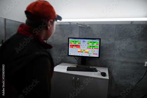 Auto mechanic sets american SUV car for diagnostics and configuration camber check in workshop of service station..