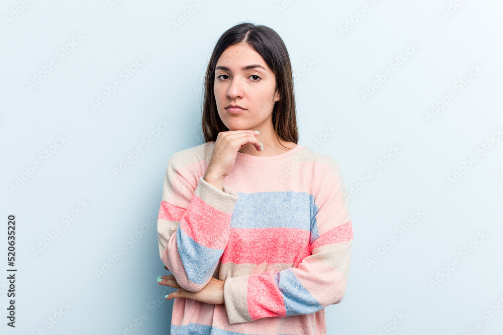 Young caucasian woman isolated on blue background suspicious, uncertain, examining you. Young caucasian woman isolated on blue background suspicious, uncertain, examining you.