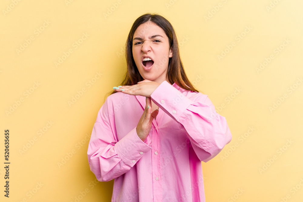 Young caucasian woman isolated on yellow background showing a timeout gesture. Young caucasian woman isolated on yellow background showing a timeout gesture.