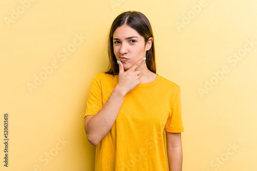 Young caucasian woman isolated on yellow background contemplating, planning a strategy, thinking about the way of a business.