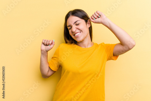 Foto Young caucasian woman isolated on yellow background celebrating a special day, jumps and raise arms with energy