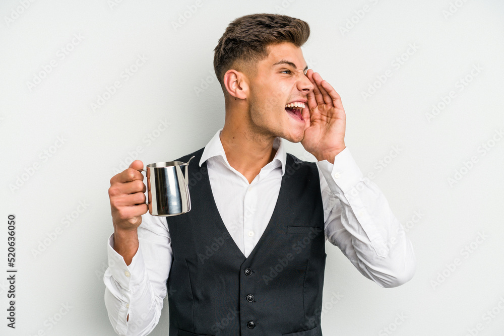 Young caucasian barista man isolated on yellow background shouting and holding palm near opened mouth. Young caucasian barista man isolated on yellow background shouting and holding palm near opened mouth.