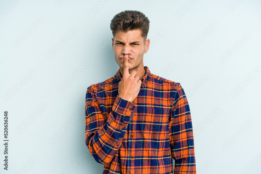 Young caucasian man isolated on blue background thinking and looking up, being reflective, contemplating, having a fantasy. Young caucasian man isolated on blue background thinking and looking up, being reflective, contemplating, having a fantasy.
