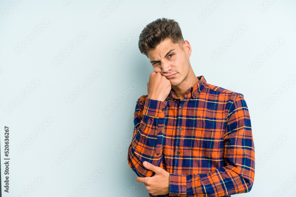 Young caucasian man isolated on blue background who feels sad and pensive, looking at copy space. Young caucasian man isolated on blue background who feels sad and pensive, looking at copy space.