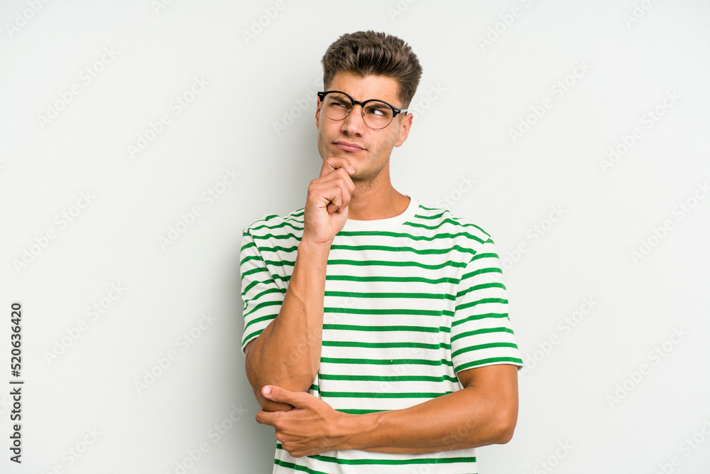Young caucasian man isolated on white background thinking and looking up, being reflective, contemplating, having a fantasy. Young caucasian man isolated on white background thinking and looking up, being reflective, contemplating, having a fantasy.