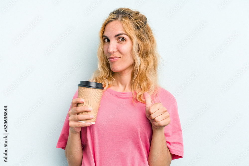 Young caucasian woman holding a take away coffee isolated on blue background feels proud and self confident, example to follow. Young caucasian woman holding a take away coffee isolated on blue background feels proud and self confident, example to follow.