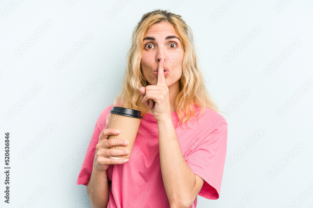 Young caucasian woman holding a take away coffee isolated on blue background keeping a secret or asking for silence.