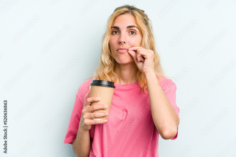 Young caucasian woman holding a take away coffee isolated on blue background with fingers on lips keeping a secret. Young caucasian woman holding a take away coffee isolated on blue background with fingers on lips keeping a secret.