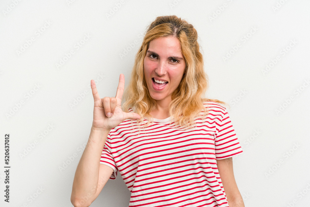 Young caucasian woman isolated on white background showing a horns gesture as a revolution concept. Young caucasian woman isolated on white background showing a horns gesture as a revolution concept.